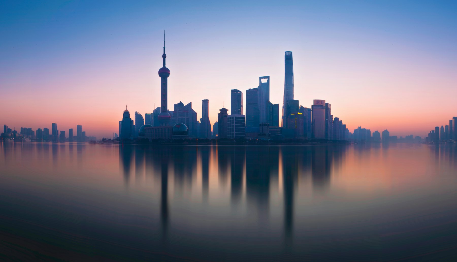 Vista do rio Huangpu e do skyline de Pudong ao anoitecer, em Xangai